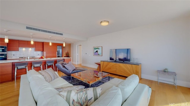 living room with light wood-type flooring and sink