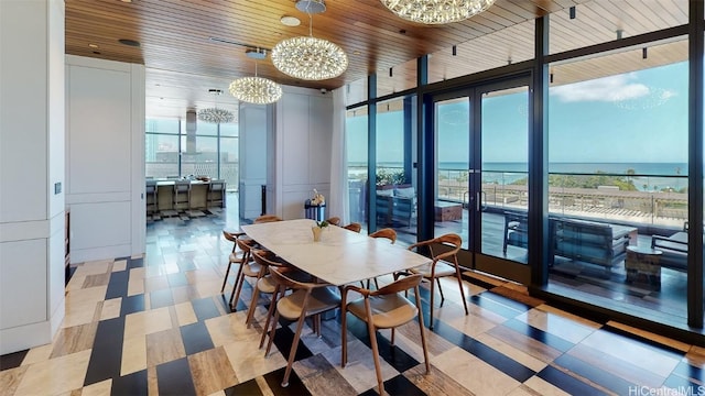 dining space featuring wooden ceiling, a water view, and a chandelier