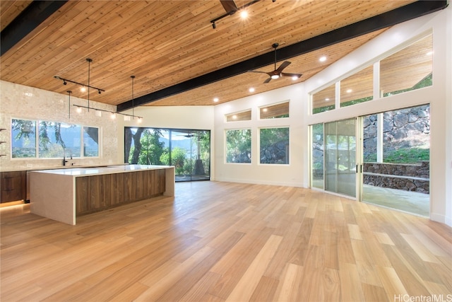 interior space with beamed ceiling, light hardwood / wood-style floors, and hanging light fixtures