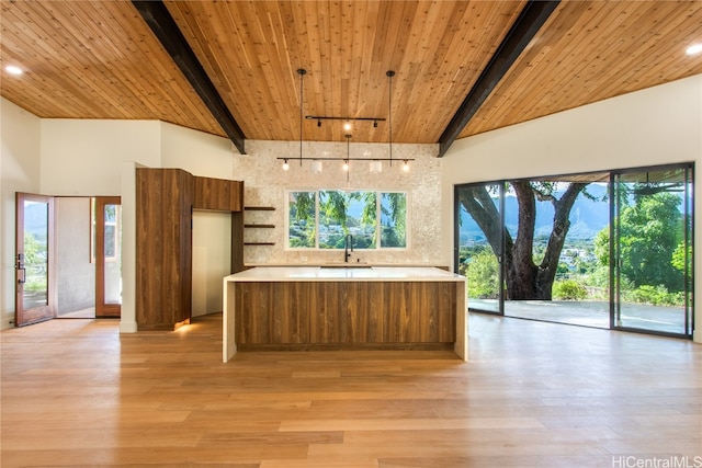 kitchen featuring decorative light fixtures, light hardwood / wood-style floors, wooden ceiling, and sink