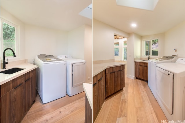 laundry room with washer and clothes dryer, a wealth of natural light, sink, and light hardwood / wood-style floors