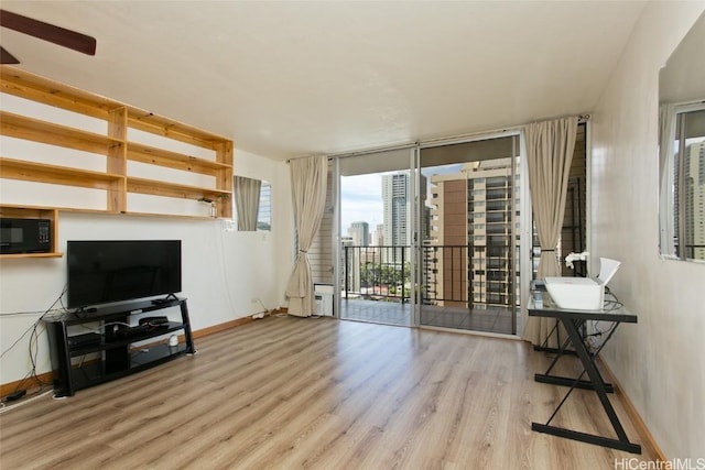 living room featuring light wood-type flooring and ceiling fan