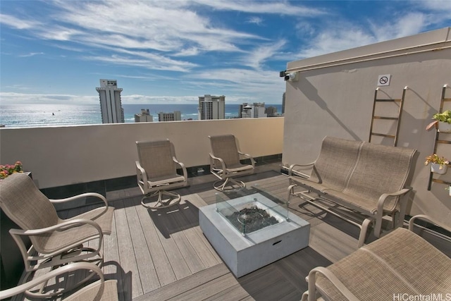 deck with a water view and a fire pit