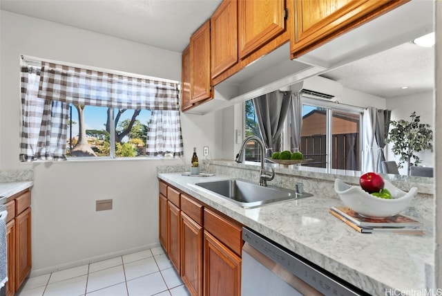 kitchen featuring dishwasher, light tile patterned floors, sink, a wall unit AC, and light stone counters