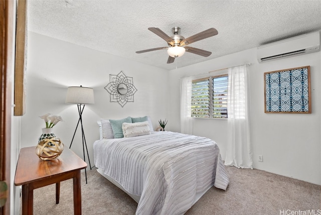 bedroom with ceiling fan, a textured ceiling, light carpet, and a wall unit AC