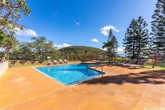 view of swimming pool featuring a mountain view and a patio area