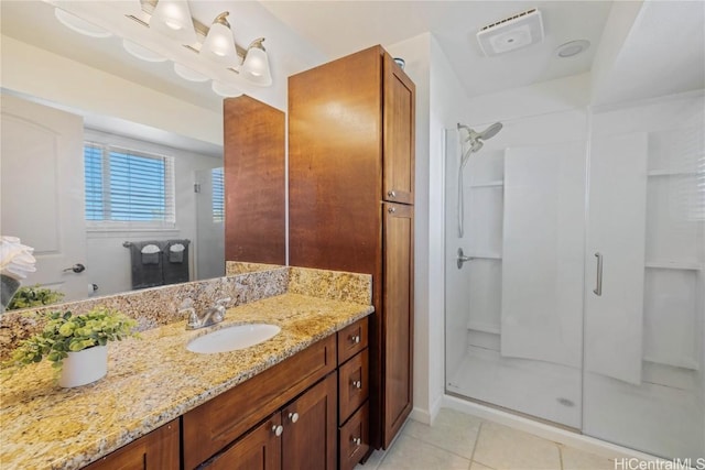 bathroom featuring tile patterned floors, an enclosed shower, and vanity