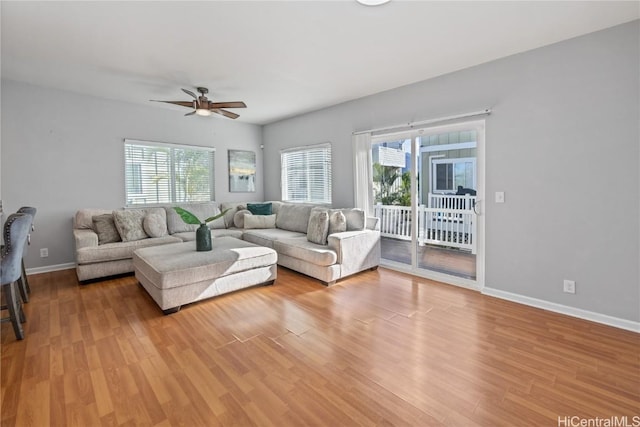 living room featuring ceiling fan, light hardwood / wood-style flooring, and a wealth of natural light