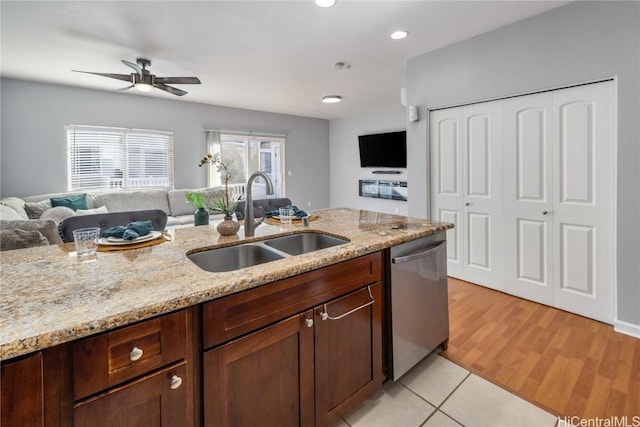 kitchen with sink, dishwasher, ceiling fan, light stone countertops, and light hardwood / wood-style floors