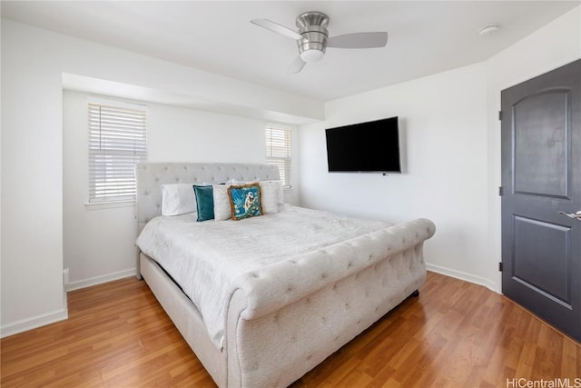 bedroom featuring multiple windows, hardwood / wood-style floors, and ceiling fan