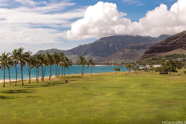 view of property's community with a water and mountain view and a lawn