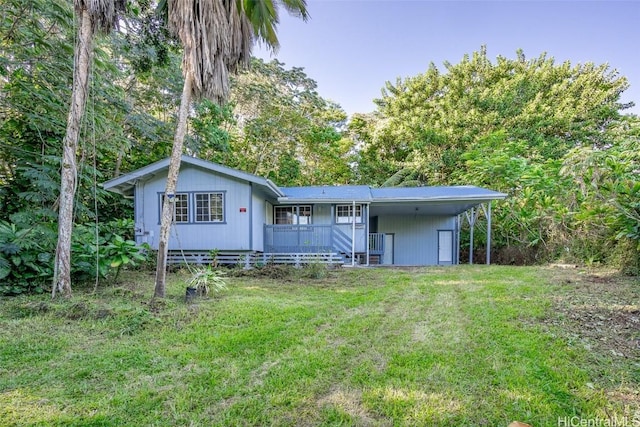 rear view of house featuring a porch, a yard, and a carport