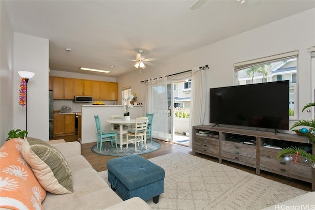 living room with light hardwood / wood-style floors and ceiling fan