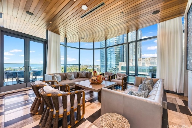 sunroom with a water view, wood ceiling, and french doors