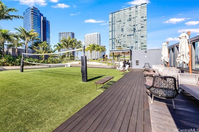 wooden deck with volleyball court and a lawn