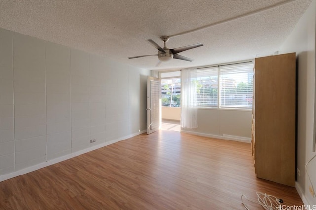 unfurnished room featuring ceiling fan, light hardwood / wood-style flooring, and a textured ceiling