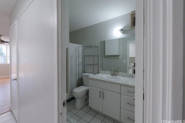 bathroom featuring tile patterned floors, vanity, toilet, and walk in shower