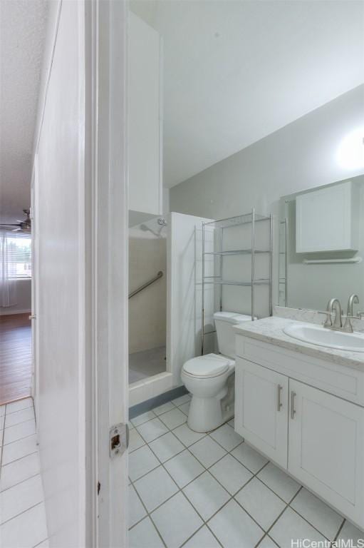 bathroom featuring tile patterned floors, a shower, vanity, and toilet