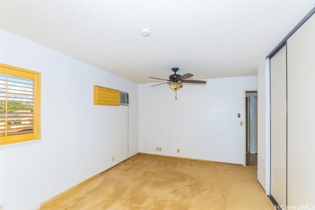 spare room featuring ceiling fan, light colored carpet, and a textured ceiling