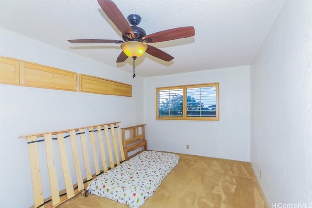 carpeted spare room with a textured ceiling and ceiling fan