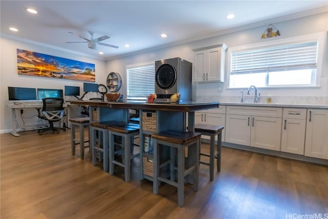 kitchen featuring sink, crown molding, dark wood-type flooring, and white cabinets