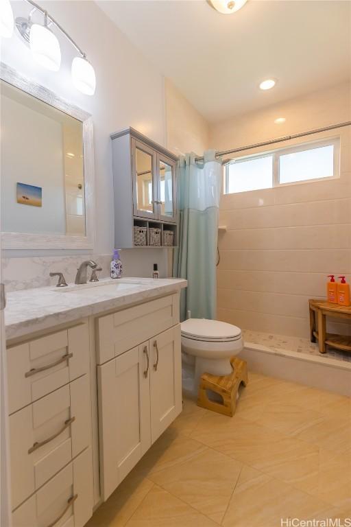 bathroom with a shower with curtain, tile patterned floors, vanity, and toilet