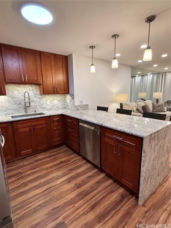 kitchen with kitchen peninsula, sink, pendant lighting, dishwasher, and dark hardwood / wood-style floors