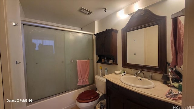 full bathroom with shower / bath combination with glass door, vanity, and toilet