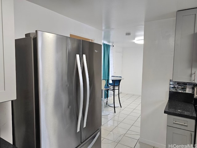 kitchen with stainless steel refrigerator, gray cabinets, and light tile patterned flooring