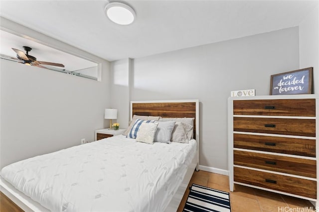 tiled bedroom featuring ceiling fan