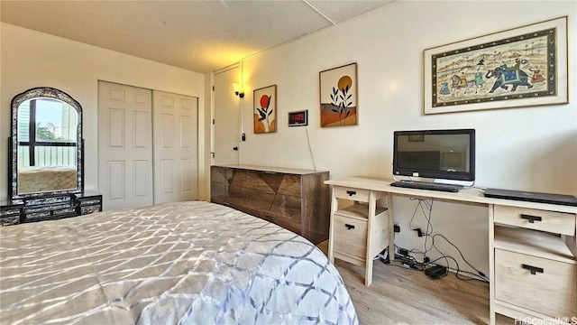 bedroom featuring a closet, a textured ceiling, and light hardwood / wood-style flooring