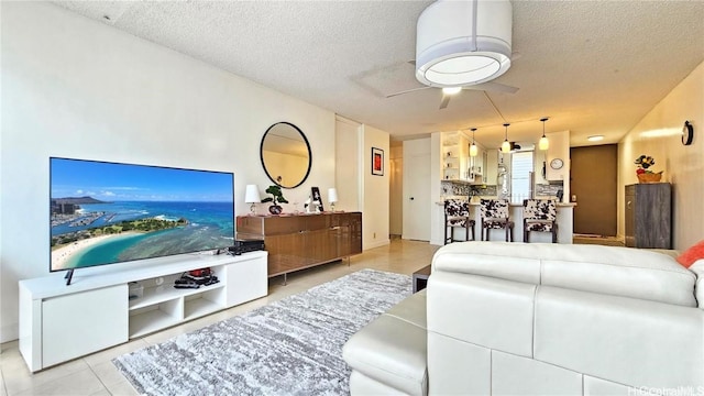 tiled living room with a textured ceiling and ceiling fan