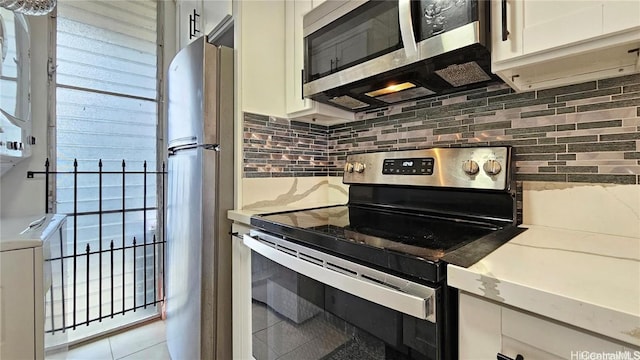 kitchen with white cabinets, stainless steel appliances, and tasteful backsplash