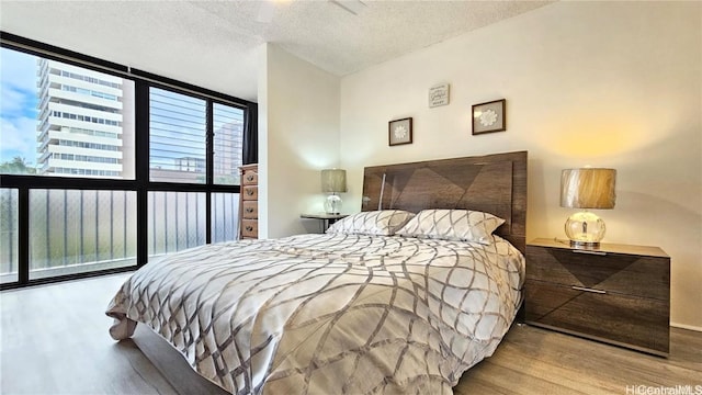 bedroom featuring a textured ceiling, light hardwood / wood-style floors, and ceiling fan