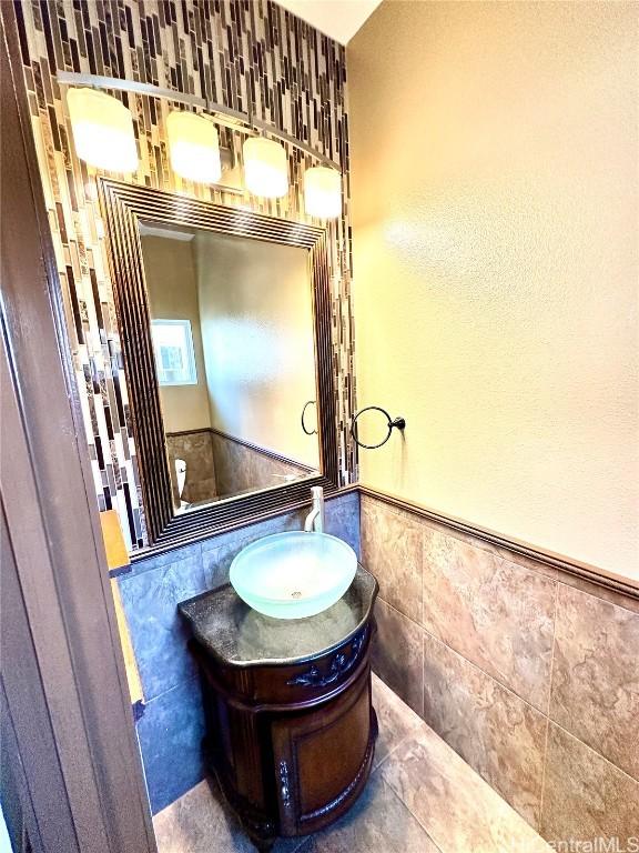 bathroom with tile patterned floors, vanity, and tile walls