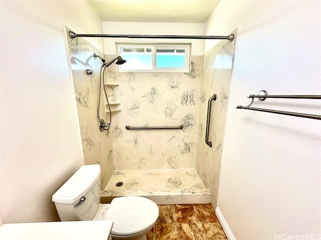 bathroom featuring tiled shower and toilet