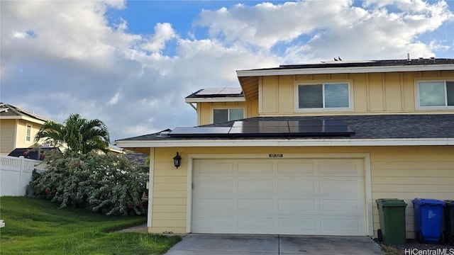 garage with a yard and solar panels