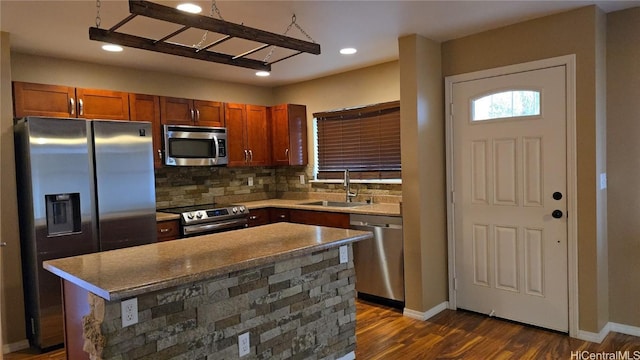 kitchen featuring backsplash, sink, dark hardwood / wood-style floors, appliances with stainless steel finishes, and a kitchen island