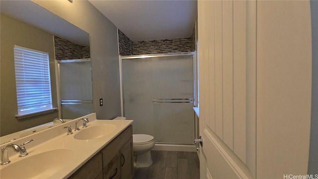 bathroom with vanity, hardwood / wood-style flooring, toilet, and an enclosed shower