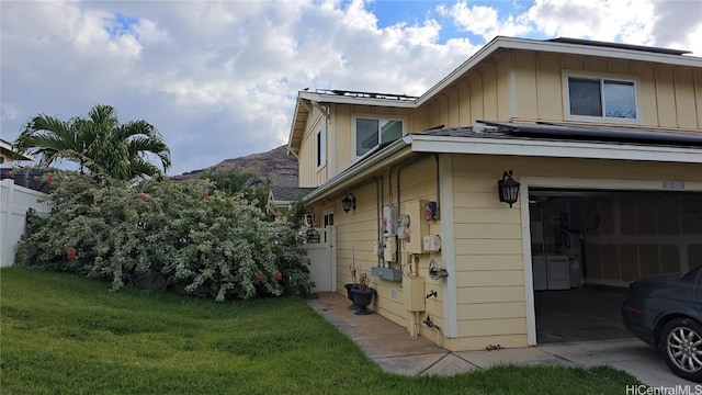 view of property exterior with independent washer and dryer, a yard, and a garage