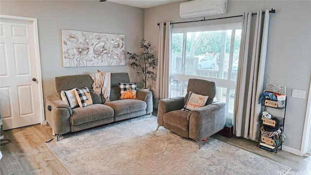 sitting room featuring an AC wall unit and hardwood / wood-style floors