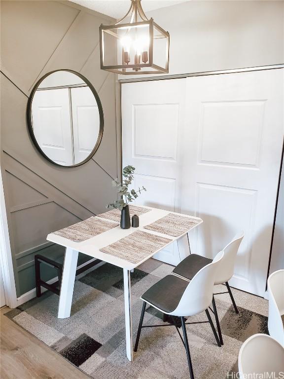 dining space featuring hardwood / wood-style flooring and an inviting chandelier