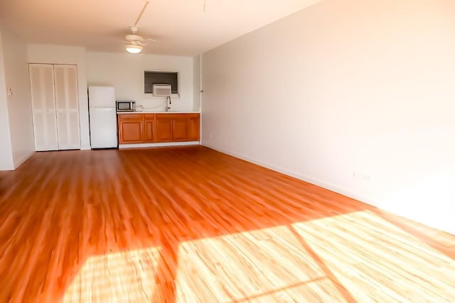 unfurnished living room with light hardwood / wood-style flooring and ceiling fan