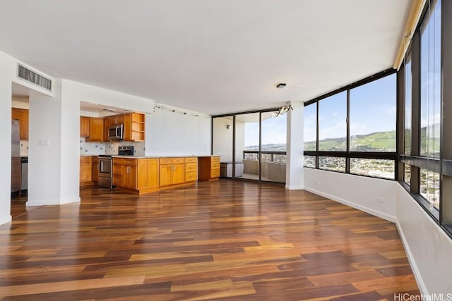 unfurnished living room featuring dark wood-type flooring, visible vents, and baseboards