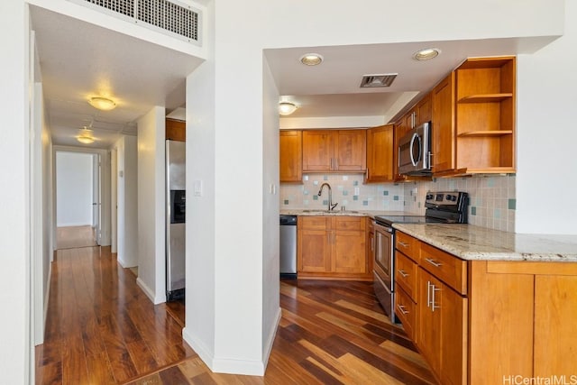 kitchen with light stone counters, open shelves, visible vents, appliances with stainless steel finishes, and a sink