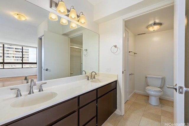 bathroom featuring visible vents, a sink, toilet, and double vanity