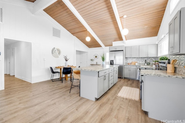 kitchen with high vaulted ceiling, a kitchen island, light hardwood / wood-style floors, a kitchen bar, and stainless steel fridge with ice dispenser