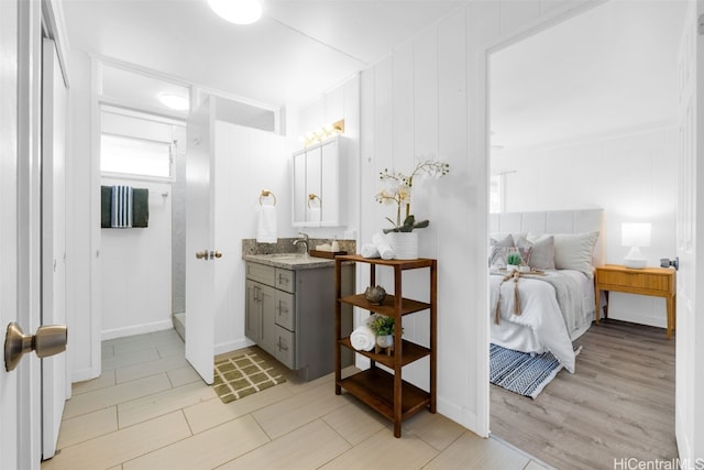 bathroom with hardwood / wood-style flooring, vanity, and wood walls