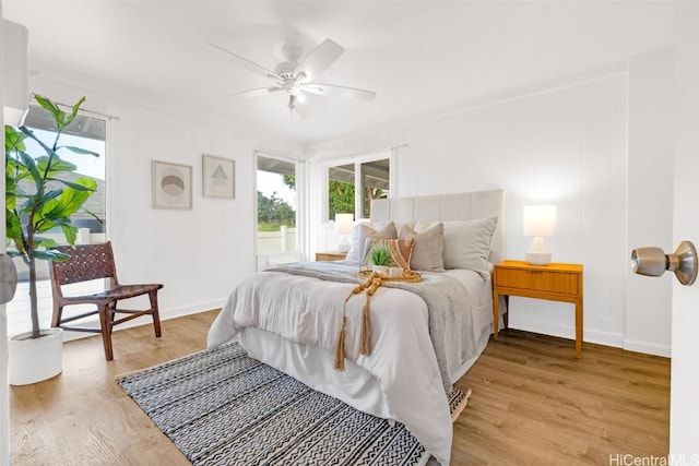 bedroom featuring light hardwood / wood-style flooring, ceiling fan, and crown molding