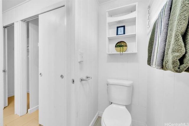 bathroom featuring hardwood / wood-style floors, toilet, and wooden walls